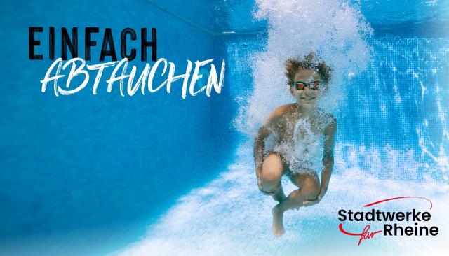Unterwasserfoto eines Jungen, der gerade in den Pool gesprungen ist